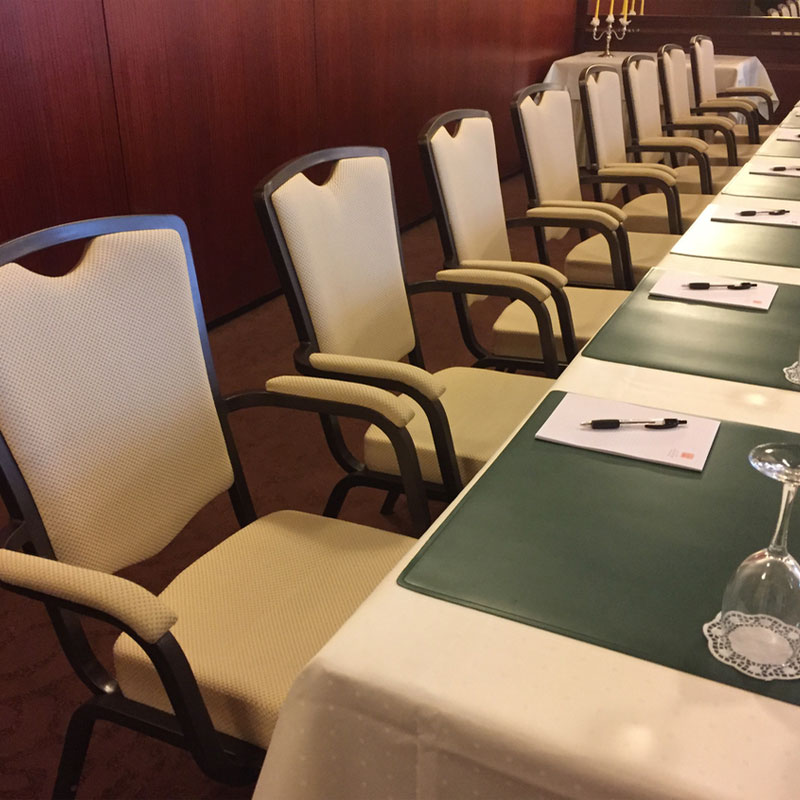 INTERA® PREMIUM Bankettstuhl – komfortable Konferenzbestuhlung mit Armlehnen - Hantermann - Der Hotelausstatter INTERA® PREMIUM Bankettstühle mit Armlehnen und heller Polsterung an einer langen Konferenztischreihe