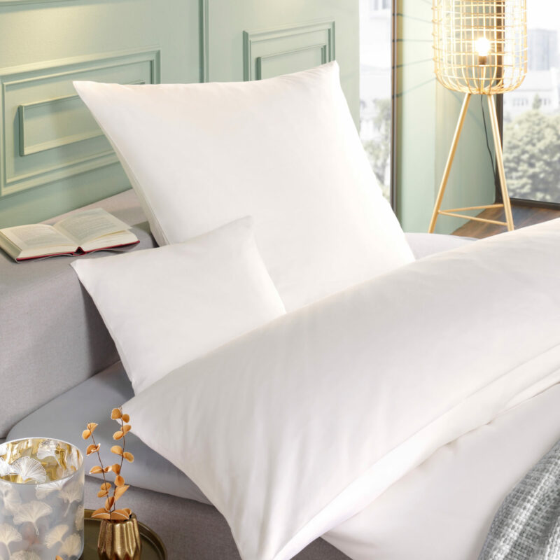 5 STERNE EDELSATIN Bettwäsche in Weiß auf Boxspringbett, mit Kissen und Decke in modernem Hotelzimmerambiente