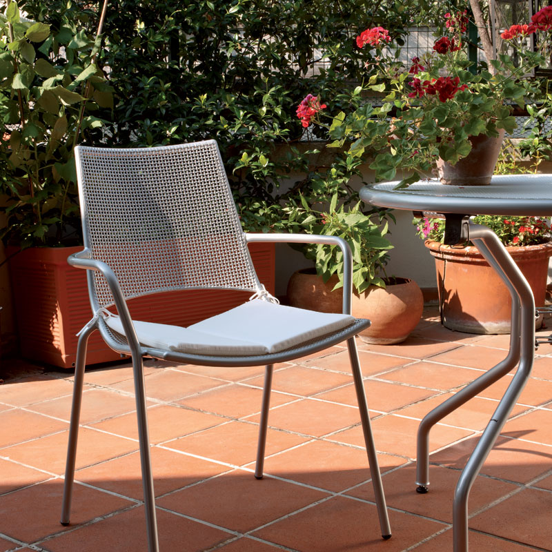 ALA 151 by EMU® – Outdoor-Stapelsessel für sonnige Terrassen - Hantermann - Der Hotelausstatter ALA 151 Outdoor-Stapelsessel von EMU® mit Sitzkissen auf einer begrünten Terrasse