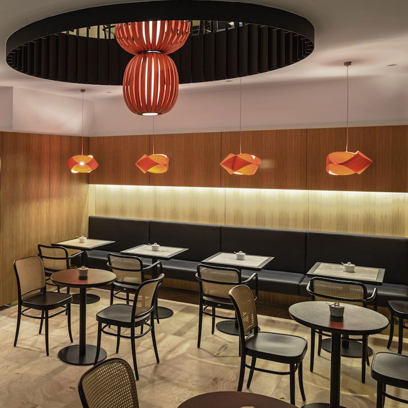 Bugholz Restaurantstuhl Modell 811 von TON – stilvoller Wiener Caféstuhl mit Armlehnen im Café-Interieur - Hantermann - Der Hotelausstatter Modernes Café mit Bugholz Restaurantstühlen Modell 811 von TON, Wiener Geflecht, runden Tischen und markanter roter Zentralleuchte