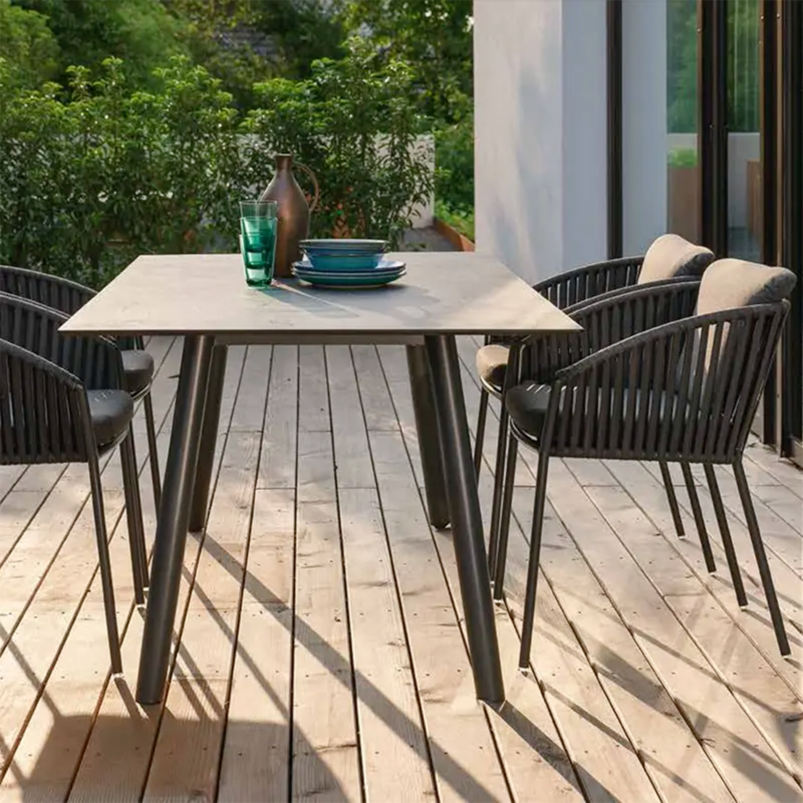 CLIFF Stapelsessel für moderne Terrassenbereiche - Hantermann - Der Hotelausstatter CLIFF Outdoor Stapelsessel von STERN® in Dunkelgrau mit Gurtbespannung rund um einen modernen Terrassentisch
