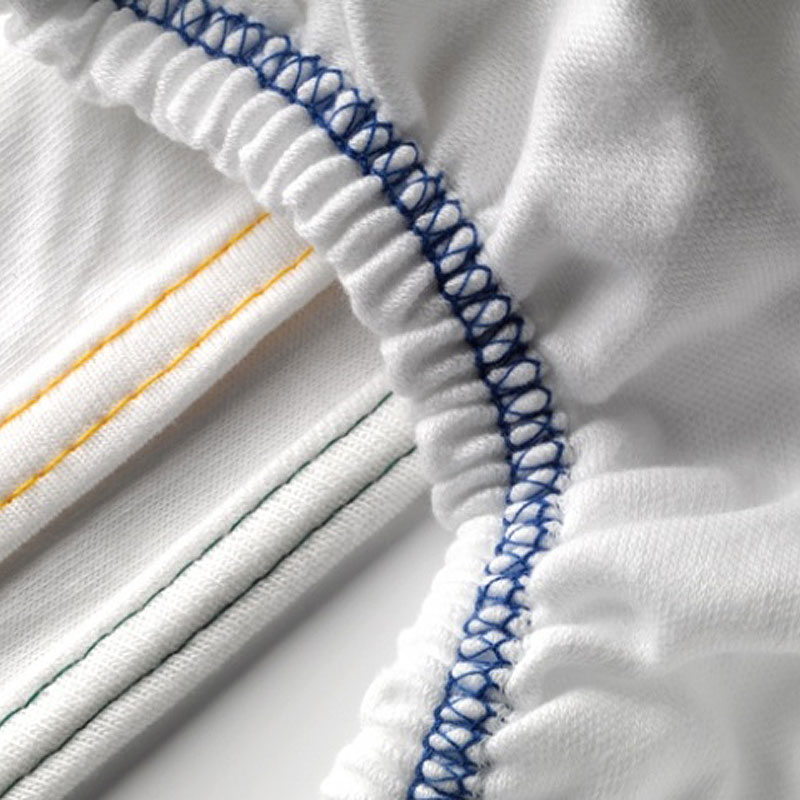 Detail LISSABON Jersey-Spannbetttuch – Gummizug und Farbcodierung für unterschiedliche Steghöhen - Hantermann - Der Hotelausstatter Detailaufnahme LISSABON Jersey-Spannbetttuch mit blauem Gummizug und farbigen Nähten zur Kennzeichnung verschiedener Größen