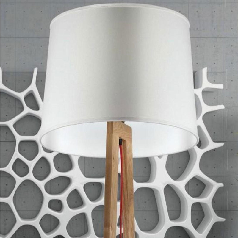 Stehlampe OKIMA LUNA – Moderne Holz-Stehleuchte mit weißem Lampenschirm - Hantermann - Der Hotelausstatter Detailaufnahme der Stehlampe OKIMA LUNA mit großem weißem Lampenschirm, natürlichem Holzgestell und rotem Stromkabel vor einer modernen grauen Wand mit dekorativen weißen Elementen