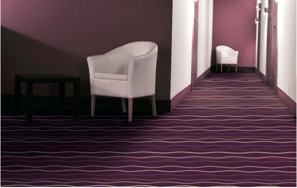Hotelteppich 08 – violetter Wellenlinien-Teppich für Flure & Laufwege im Hotel - Hantermann - Der Hotelausstatter Hotel-Flur mit violettem Hotelteppich 08 im Wellenlinien-Design und weißen Sesseln