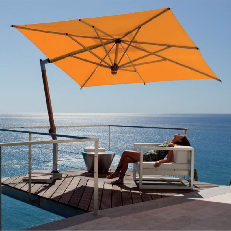 ISCHIA Ampelschirm von FIM mit orangefarbener Bespannung auf einer modernen Terrasse mit Meerblick