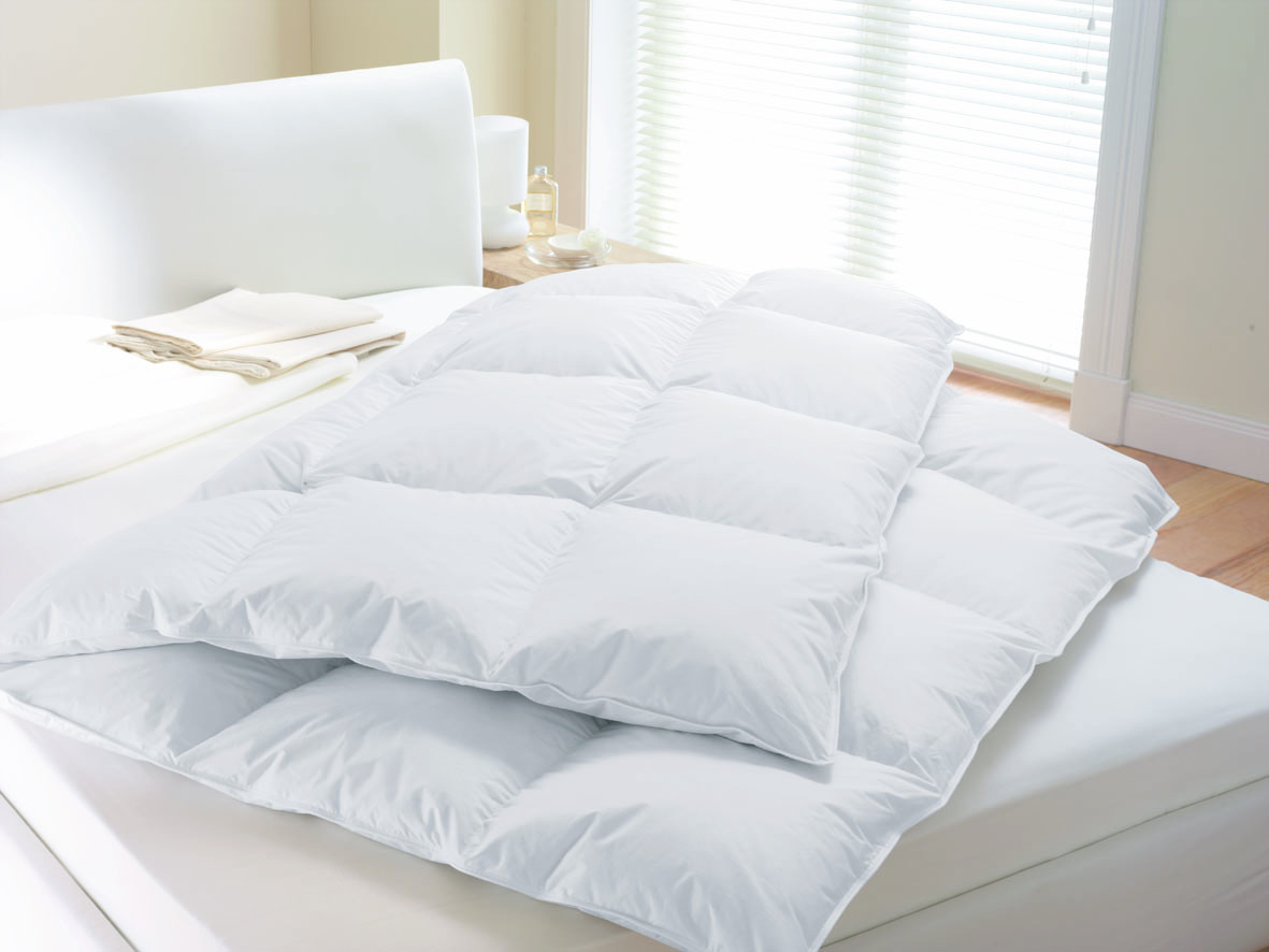LUXURY Gänsedaunen-Kassettendecke – weiße Premium-Daunendecke in Hotel-Qualität - Hantermann - Der Hotelausstatter LUXURY Gänsedaunen-Kassettendecke in Weiß, voluminöse Daunendecke auf einem hellen Bett im Schlafzimmer