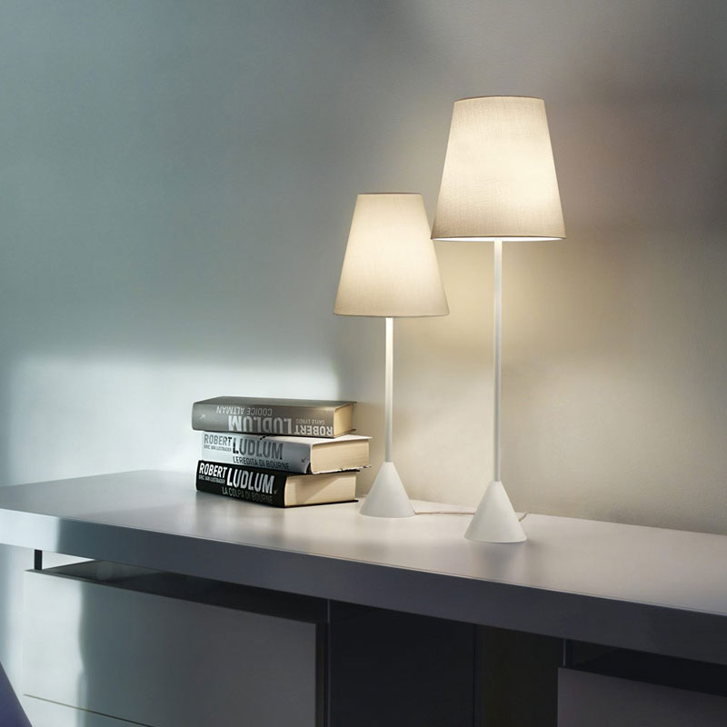 Nachttischlampe und Schreibtischlampe LYNDA in Weiß mit konischem Stofflampenschirm, schlankem Leuchtenstab und fest montierter Ausführung ohne Standfuß auf einem modernen Sideboard