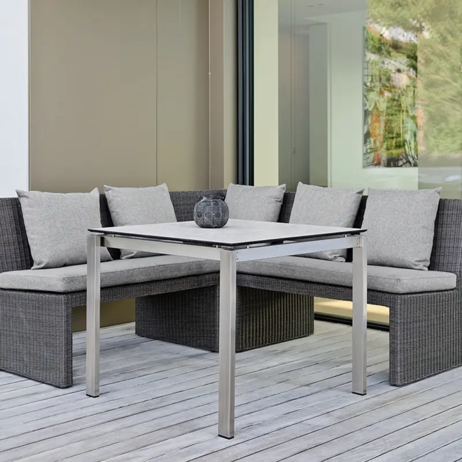 NOEL Outdoor-Bank von STERN® – gemütliche Ecklounge - Hantermann - Der Hotelausstatter NOEL Outdoor-Bank von STERN® als großzügige Ecklounge mit grauen Polstern und modernem Geflecht auf einer Terrasse