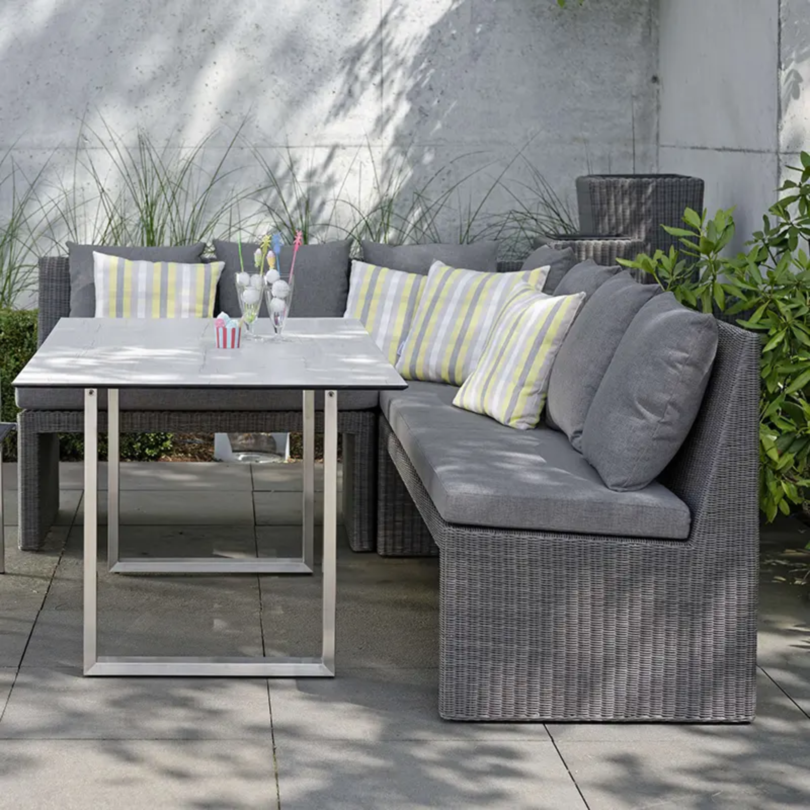 NOEL Outdoor-Loungegruppe von STERN® auf der Terrasse - Hantermann - Der Hotelausstatter NOEL Outdoor-Loungegruppe von STERN® mit grauem Geflecht, Polstern und modernem Tisch auf einer Terrasse