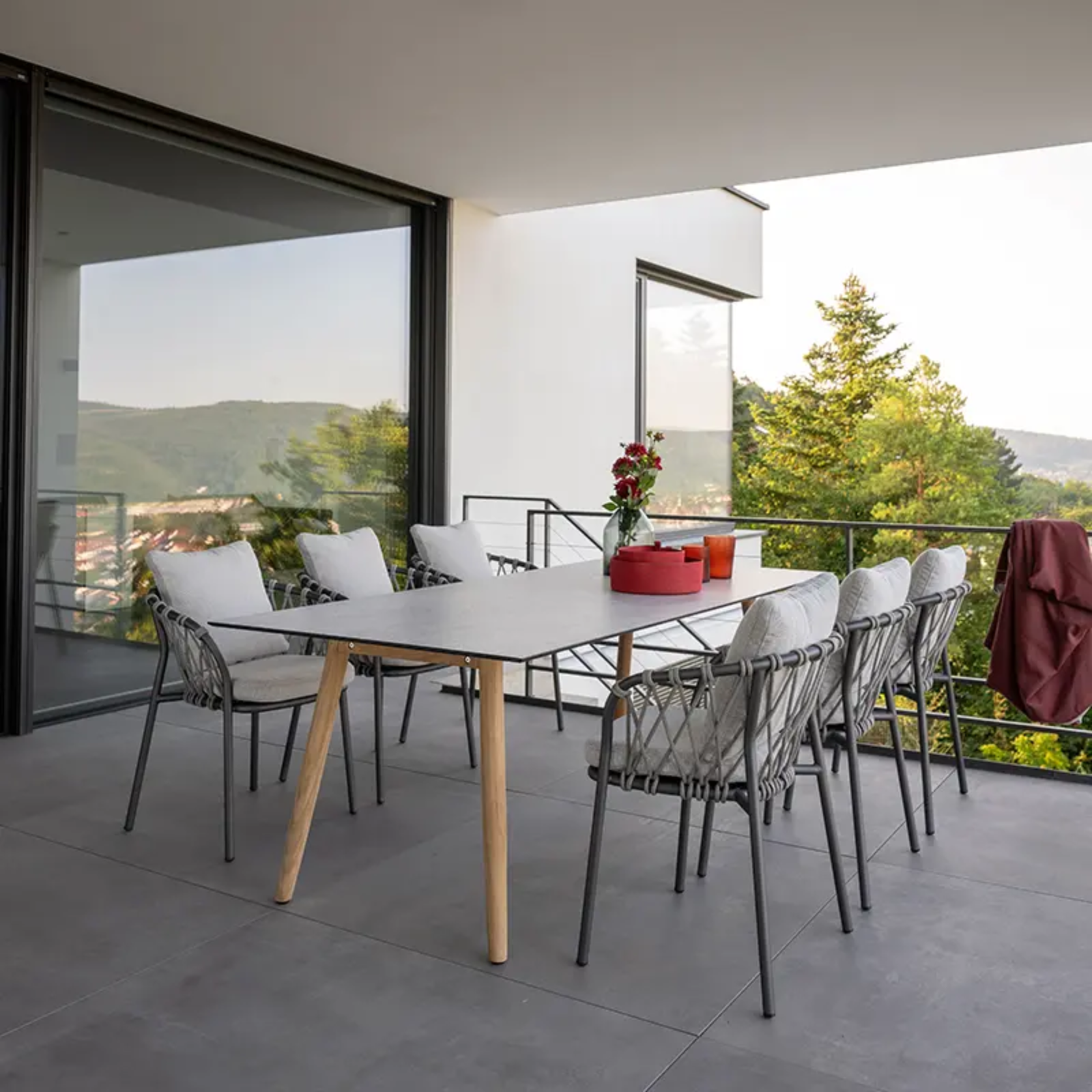 Outdoor-Sessel von STERN® für stilvolle Terrassen - Hantermann - Der Hotelausstatter Outdoor-Sessel von STERN® mit grauer Kordelbespannung und hellen Polstern an einem modernen Terrassentisch