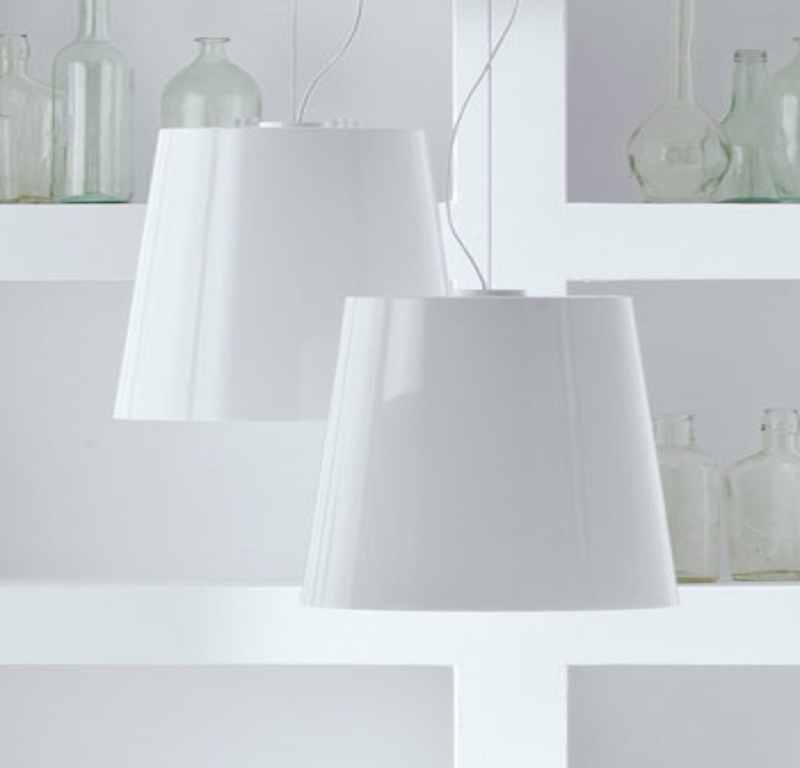PEDRALI L001 Pendelleuchten in Weiß mit konisch geformten Lampenschirmen in unterschiedlichen Größen, hängend vor einer hellen Wand mit dekorativen Glasflaschen
