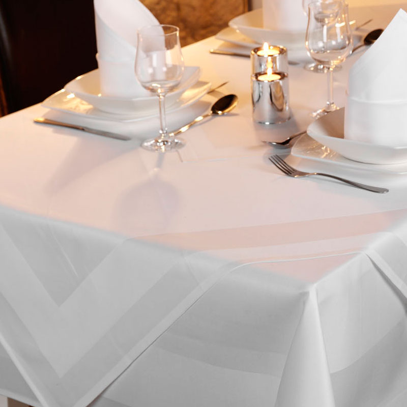 PICO Vollzwirn-Tischwäsche – klassische weiße Atlaskante für festliche Gastro-Tafeln und À-la-carte-Restaurants - Hantermann - Der Hotelausstatter PICO Vollzwirn-Tischwäsche mit weißer Atlaskante für festlich gedeckte Restauranttische mit Kerzenlicht