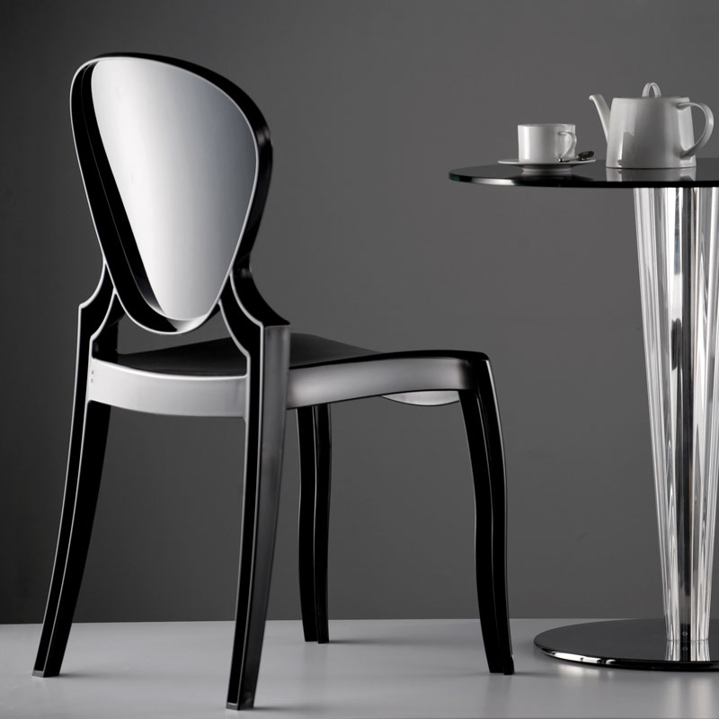 QUEEN 650 Stapelstuhl by Pedrali – schwarzer Polycarbonat-Designstuhl im monochromen Café-Setting für Hotels, Bars und Restaurants - Hantermann - Der Hotelausstatter Seitliche Ansicht QUEEN 650 Stapelstuhl von Pedrali in Schwarz neben rundem Café-Tisch mit Tasse und Teekanne