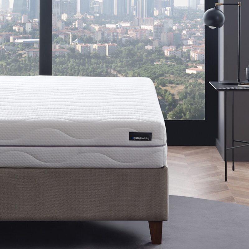 ROYAL DUO 7-Zonen Taschenfederkernmatratze H2+H3 mit 22 cm Höhe, weißem gestepptem Matratzenbezug und grauem Polsterbett in modernem Hotelzimmer
