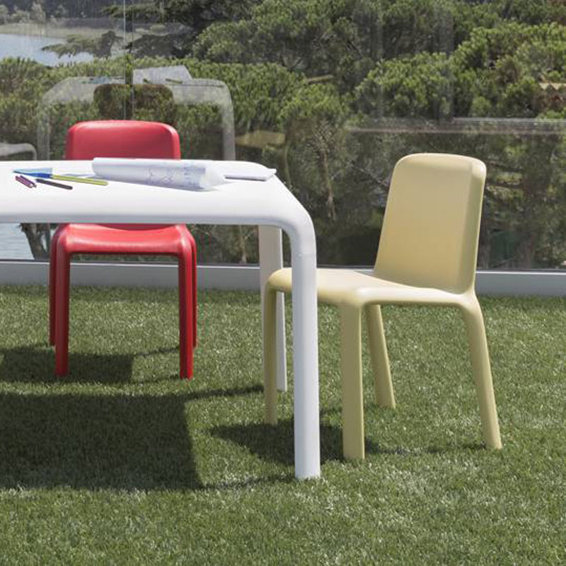 SNOW 303 Kinderstuhl by Pedrali – Outdoor-Sitzmöbel für moderne Außenbereiche - Hantermann - Der Hotelausstatter SNOW 303 Kinderstühle von Pedrali in Gelb und Rot an einem weißen Tisch im Außenbereich