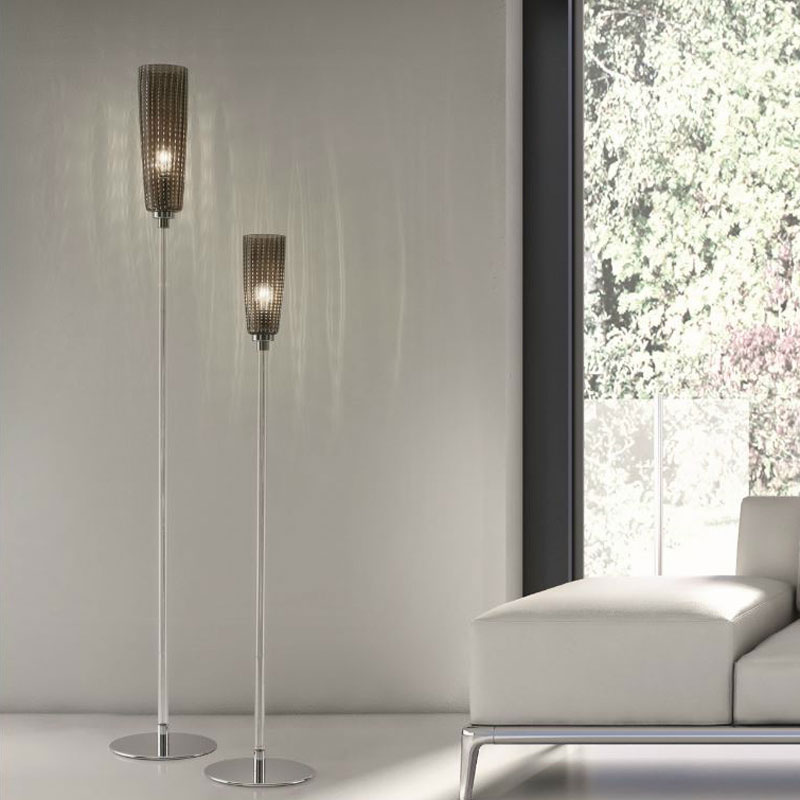 Stehlampe PERLE aus mundgeblasenem Muranoglas in zwei unterschiedlichen Höhen mit zylindrischen Glasschirmen, schlankem Metallgestell und rundem Standfuß neben einem weißen Sofa