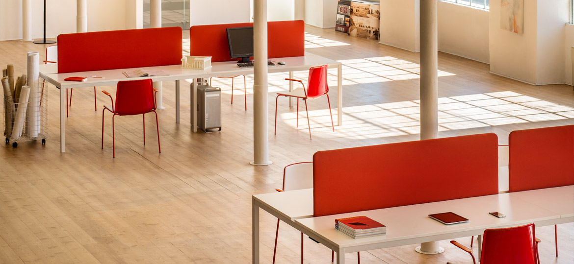 TWEET Bürostuhl-Kollektion von Pedrali – flexible Designstühle für moderne Arbeitsplätze, Konferenzräume & Coworking - Hantermann - Der Hotelausstatter Rote TWEET Stühle von Pedrali an weißen Schreibtischen in einem offenen, modernen Büro mit Arbeitsplatztrennwänden