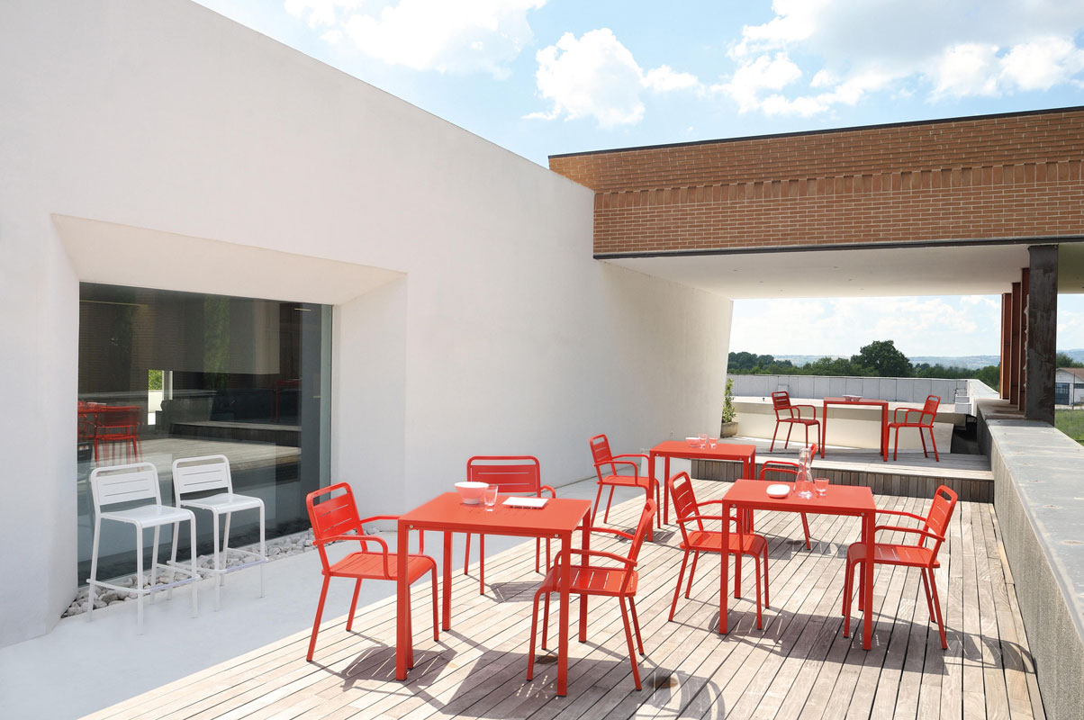 URBAN 208 Outdoor-Aluminium-Stapelstuhl by EMU – moderner Designstuhl für Terrasse, Rooftop & Gastronomie - Hantermann - Der Hotelausstatter EMU URBAN 208 Aluminium-Stapelstuhl in Rot und Weiß auf moderner Terrasse mit Outdoor-Tischen