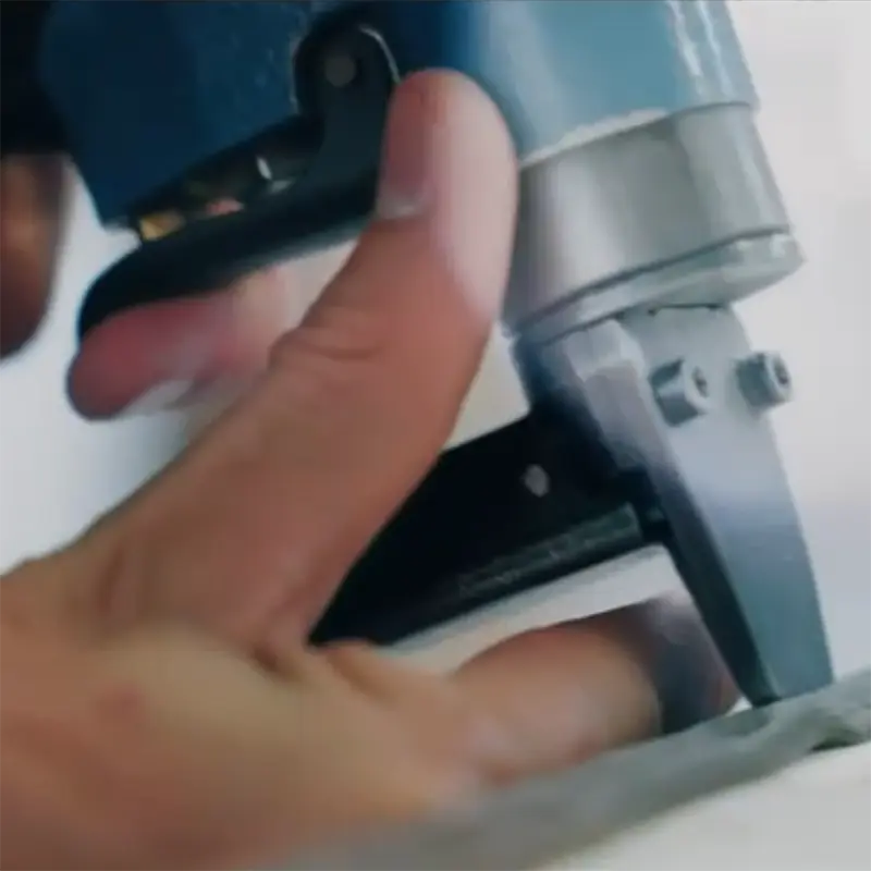 Das Bild zeigt eine Nahaufnahme einer Hand, die mit einem Tacker (Heftpistole) Stoff befestigt. Die Szene wirkt handwerklich und vermittelt Polsterarbeiten oder Möbelrestauration.