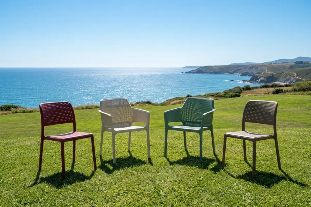 Nardi Net Gartenstühle – Design Terrassenmöbel auf Wiese am Meer - Hantermann - Der Hotelausstatter Nardi Net Gartenstühle in verschiedenen Farben auf grüner Wiese mit Meerblick für Terrasse und Gastronomie