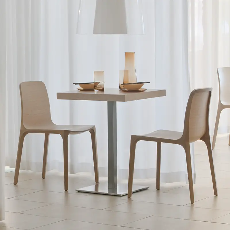 Zwei Pedrali Frida 752 Stühle an quadratischem Tisch mit Inox 4402 Gestell in hellem Restaurantambiente