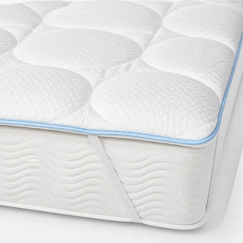 Detailaufnahme CoolAge® Topperunterbett – Matratzenauflage für erholsame Nächte - Hantermann - Der Hotelausstatter Detailaufnahme Weißes CoolAge® Topperunterbett mit oval gesteppter Matratzenauflage und umlaufender Kante vor weißem Hintergrund